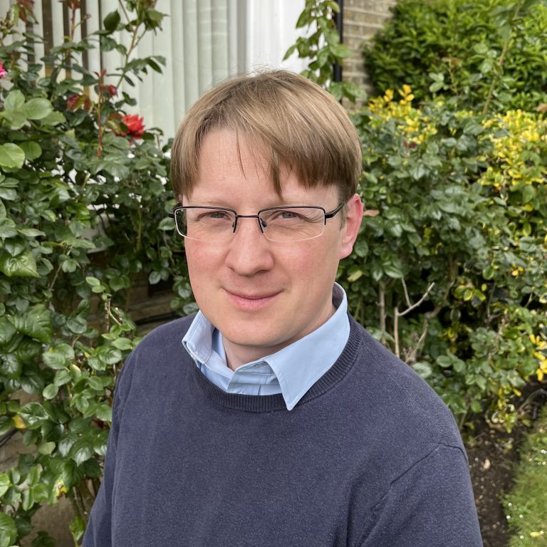 Man standing in the garden looking towards the camera