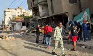 People in the street near damaged buildings