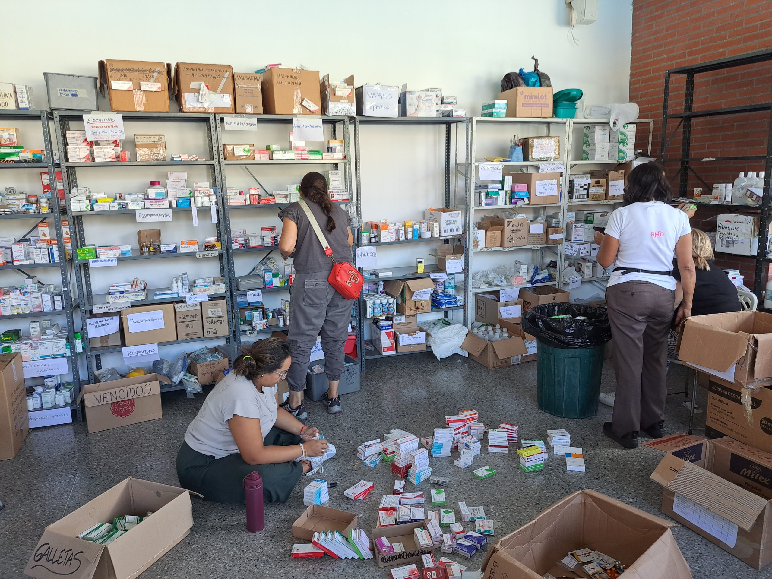 People in a warehouse sorting through medicines and toiletries