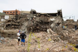 Two people looking at a damaged building