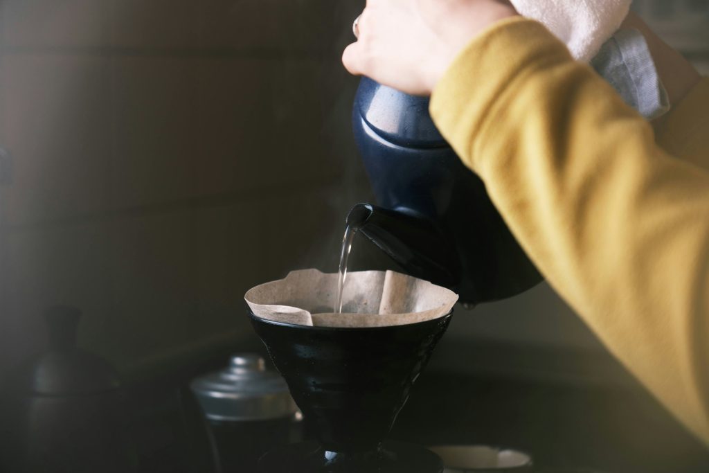 A person pouring water into a coffee filter