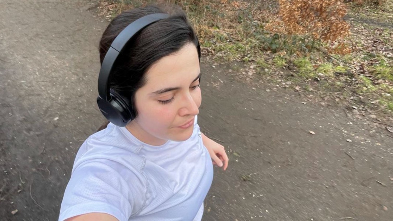 A woman wearing headphones out on a run