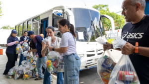 People passing bags of goods to each other in a line